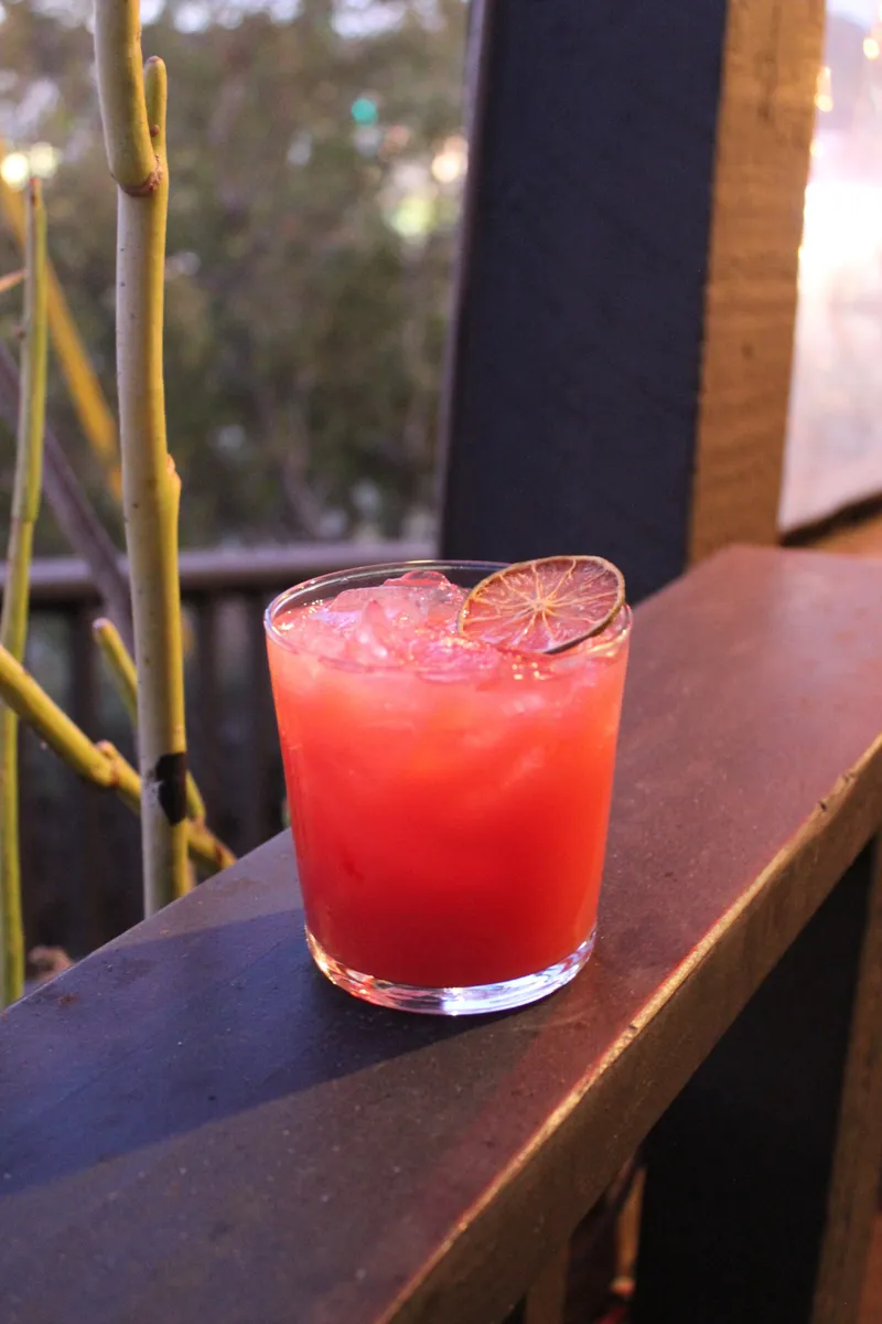 A bright cocktail served over ice