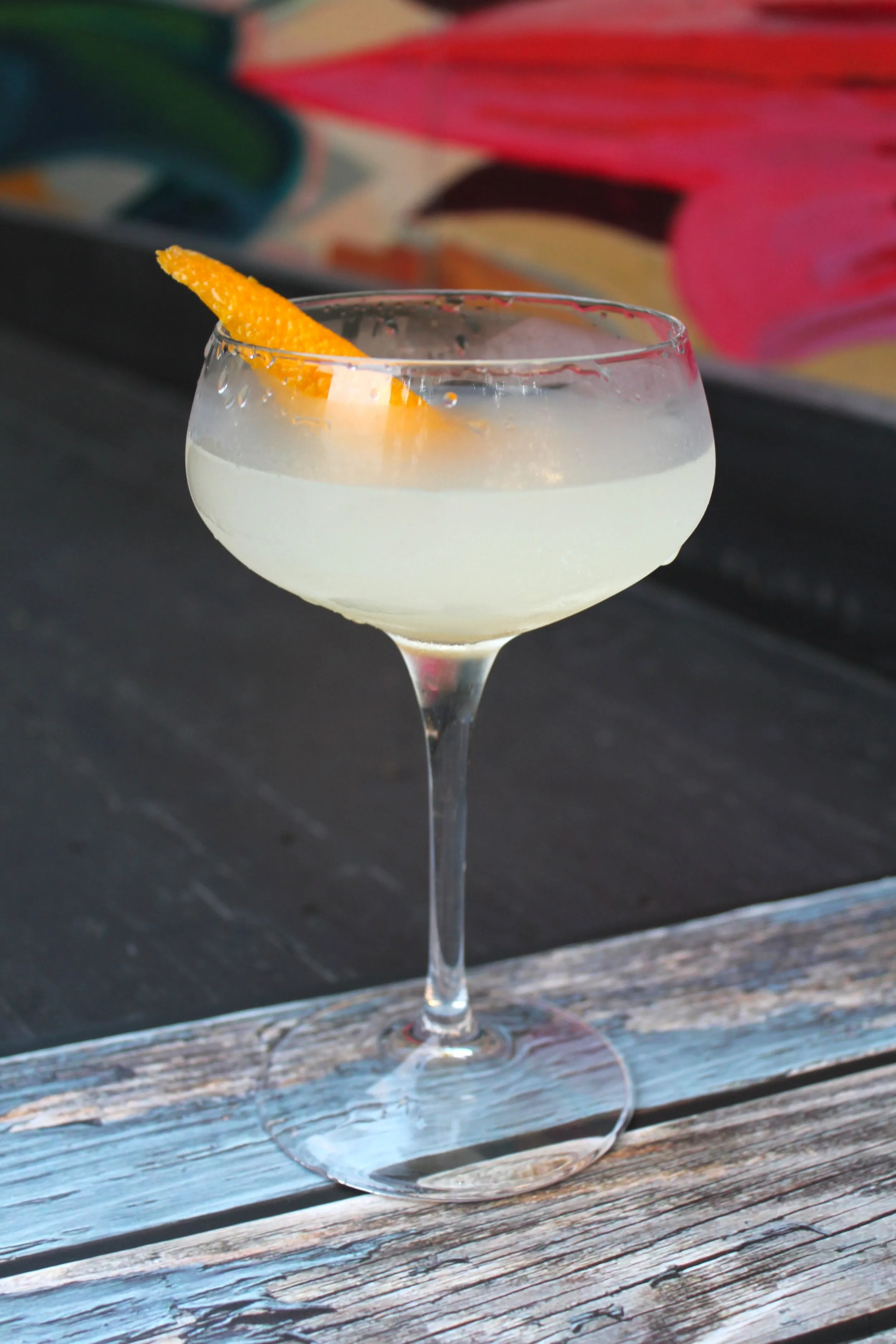 A chilled cocktail with an orange twist